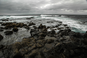 beautiful view from a stony shore to a raging ocean