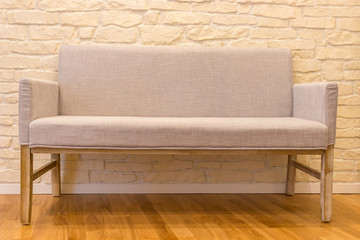 Cozy sofa in front of brick wall