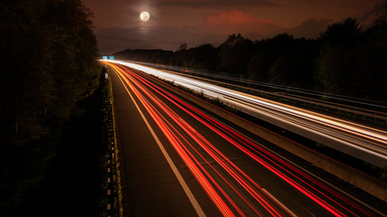 Langzeitbelichtung auf der Autobahn. Nachtlichter, Stadtlichter, Geschwindigkeit, Transport, Traffic, Autos in Bewegung, Fahrbahn, Road