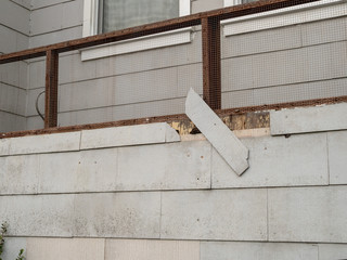 Shingle on exterior wall of house falling off in state of disrepair