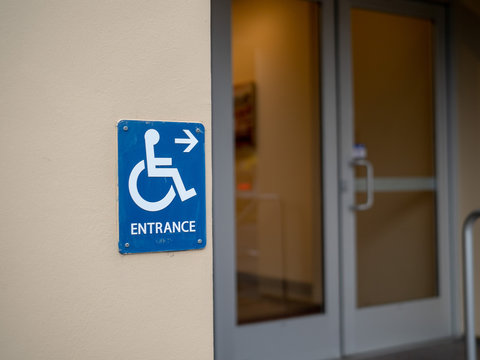 Handicap Entrance Sign Pointing To Right In Front Of Office Door