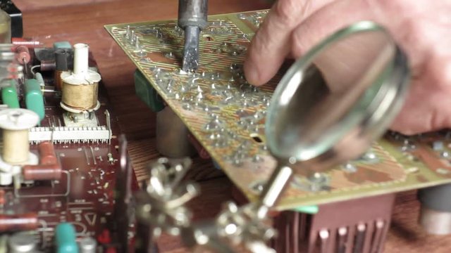 the master is engaged in repair of radio components on schemes