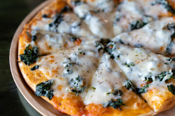 Delicious hot homemade pizza served on wooden plate.