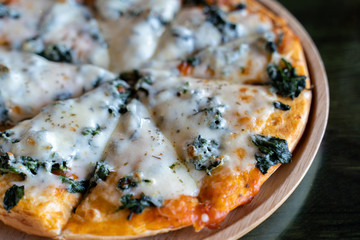 Delicious hot homemade pizza served on wooden plate.