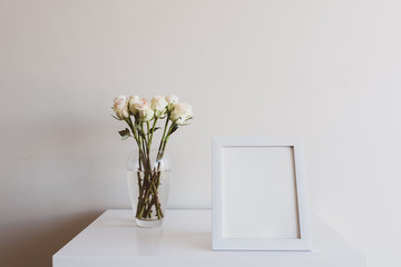 Closeup of blank rectangular picture frame with cream roses on table - matte filter effect