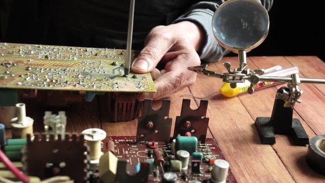 master soldering radio components on the desktop, close-up