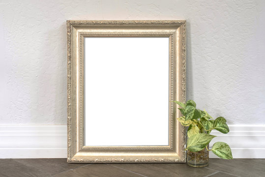 Silver pewter 8x10 picture frame with a philodendron plant on a wood textured tiled floor.  For mocking up photos and messages.