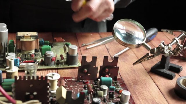 master soldering radio components on the desktop, close-up