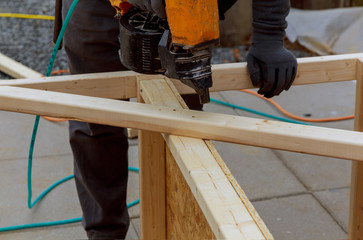 Worker installing wood floor for hammering on a deck patio