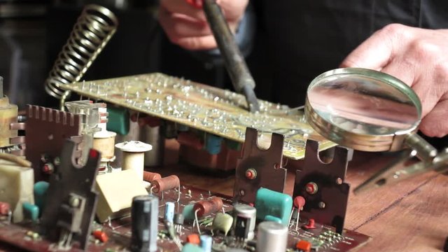 master soldering radio components on the desktop, focus on radio components