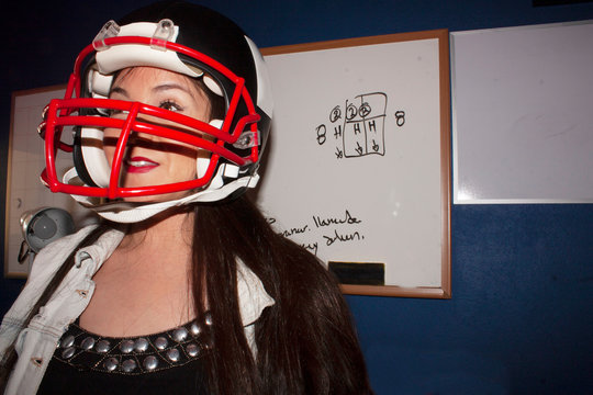 Lifestyle student woman preparing for American party at school smiling part wearing helmet with all enthusiasm