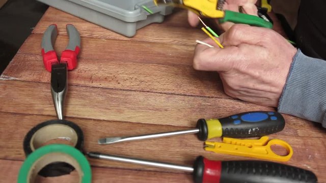 the electrician connects the wires with the help of his tools