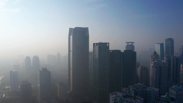 JAKARTA, Indonesia - April 25, 2019: Aerial view of silhouette of Astra office building behind smog of air pollution on the morning. Shot in 4k resolution from a drone flying forwards