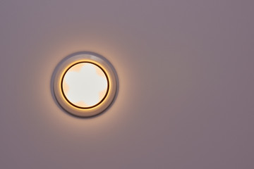 Built-in white ceiling electric LED round white matte lamp in the switched-on state. flat lay....