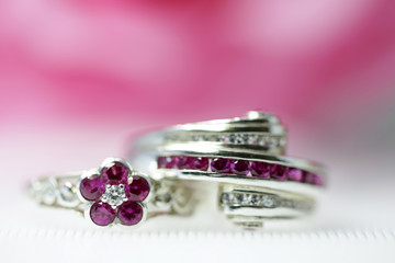Two red round gemstone rings stacked beautifully in the background.