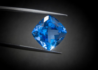 Natural Swiss Blue Topaz Cushion Shape Gems Stone oval cut beautiful.Holding a blue stone by...