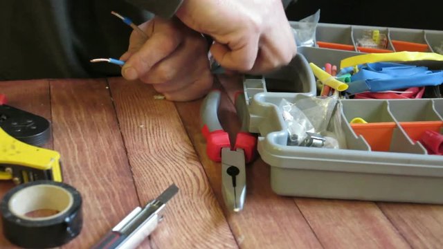 the electrician connects the wires with the help of his tools