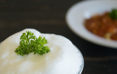 Milk froth and Parsley on Black Wood Table Left