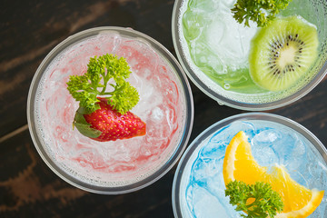 Red Green Blue Italian Soda Cold Beverage and Strawberry Kiwi Lemon Fruit Close Up