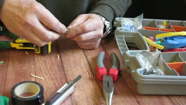 the electrician connects the wires with the help of his tools