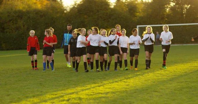 4K Winning & losing teams leave the pitch together at the end of soccer match. Slow motion.