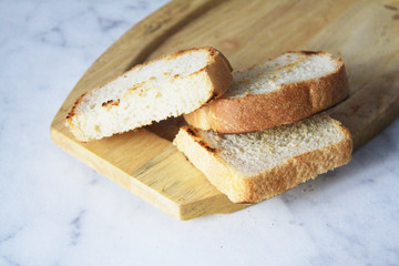 Grilled sausages and bread on a wooden Board on a marble table