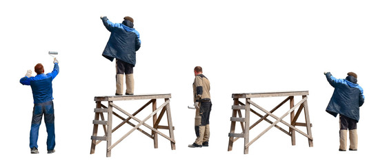 Three painters in overalls paint by hand an old wooden wall in gray