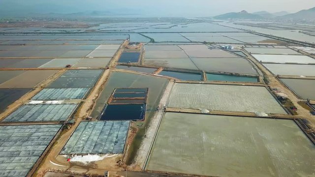 From great height structure pattern salt field endless production evaporation old technology. Natural landscape mountains horizon. Economy culture style Vietnam China Asia. Aerial Drone drift
