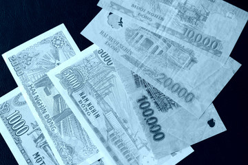 Naklejka premium Vietnamese dongs on a dark background close up. Blue color toned