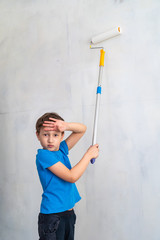 the child is tired of painting the walls. finishing work in the premises of the artist paints the walls. repair of premises, premises of the house. the child helps to paint the walls. copy space