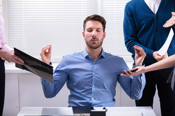 Young Businessman Meditating In Office