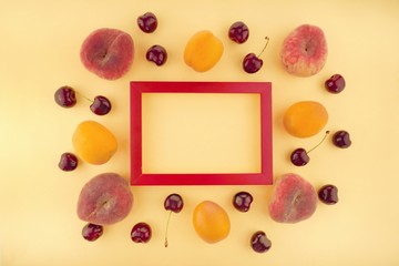 Naklejka na ściany i meble Summer fruits frame. Fruit berry pattern. apricots and peaches, sweet cherry and red currants on yellow background.Summer season.top view, copy space