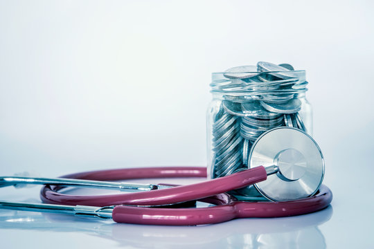 Health  insurance and Medical Healthcare disease concept , a coin money jar with stethoscope on white background