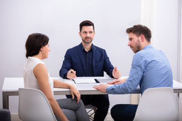 Couple Sitting In Front Of Judge - obrazy, fototapety, plakaty