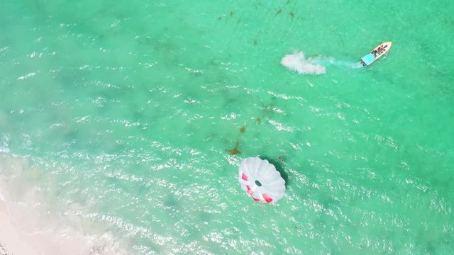 People having fun doing parasailing above Caribbean Sea. Summer holidays. Travel destination