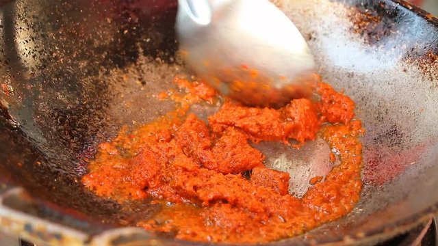 Frying red curry paste in pan to make red curry, Thai famous food