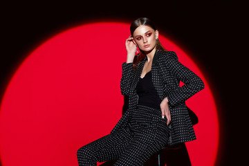 Fashion portrait of young woman in black suit in peas.