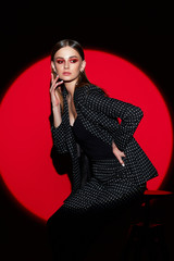 Fashion portrait of young woman in black suit in peas.