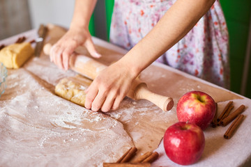 Hands working with dough preparation recipe bread. Female hands making dough for pizza. Woman's hands roll the dough. Mother rolls dough on the kitchen board with a rolling pin