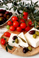 Greek feta cheese, olives and cherry tomatoes on a wooden table