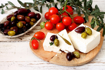 Greek feta cheese, olives and cherry tomatoes on a wooden table