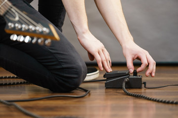 Man adjusting guitar effects pedal