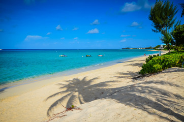 Palmboomschaduwen op Seven Mile Beach op Grand Cayman in het Caribisch gebied.