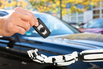 Man Giving Car Key To Robot