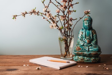candle, apricot branches and statue buddha on wooden table. Spa