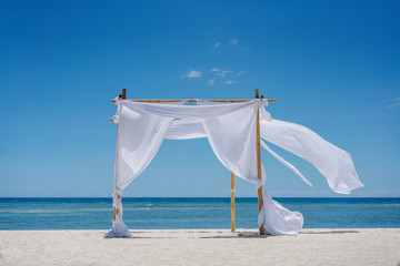 Fototapeta na wymiar Romantic place by the sea. White fabric curtains fluttering in the wind.