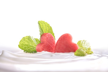 Plain yogurt with fresh heart shape watermelon on top in bowl isolated on white background