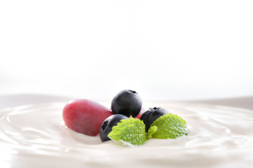 Plain yogurt with fresh fruits on top in bowl isolated on white background