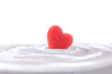 Plain yogurt with fresh heart shape watermelon on top isolated on white background