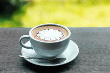 Cup of hot coffee latte on a wooden table natural beauty.